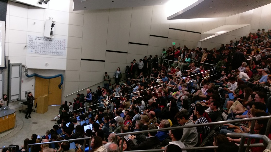 A crowded room of people listening to the talk.